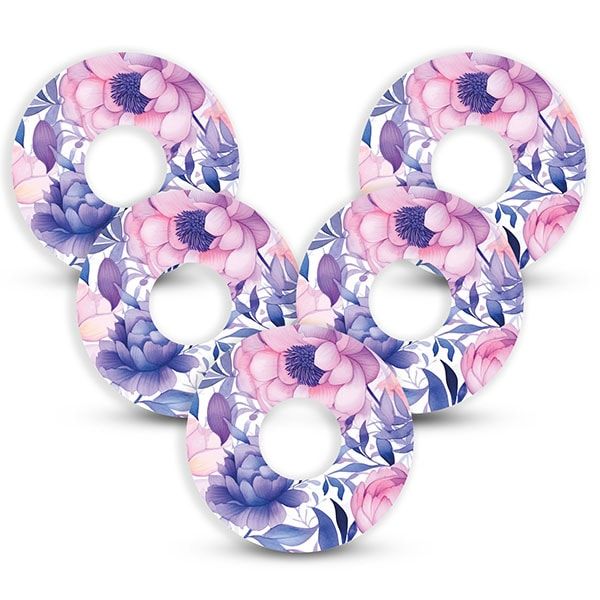 Fünf runde Fixierungspflaster mit lila Blumenmuster. Mit zentralem Loch. Wasserdicht und atmungsaktiv.