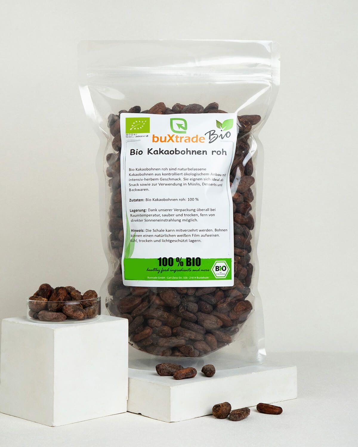 Verpackung buXtrade Bio Kakaobohnen neben einer kleinen Schale und einzelnen Bohnen.