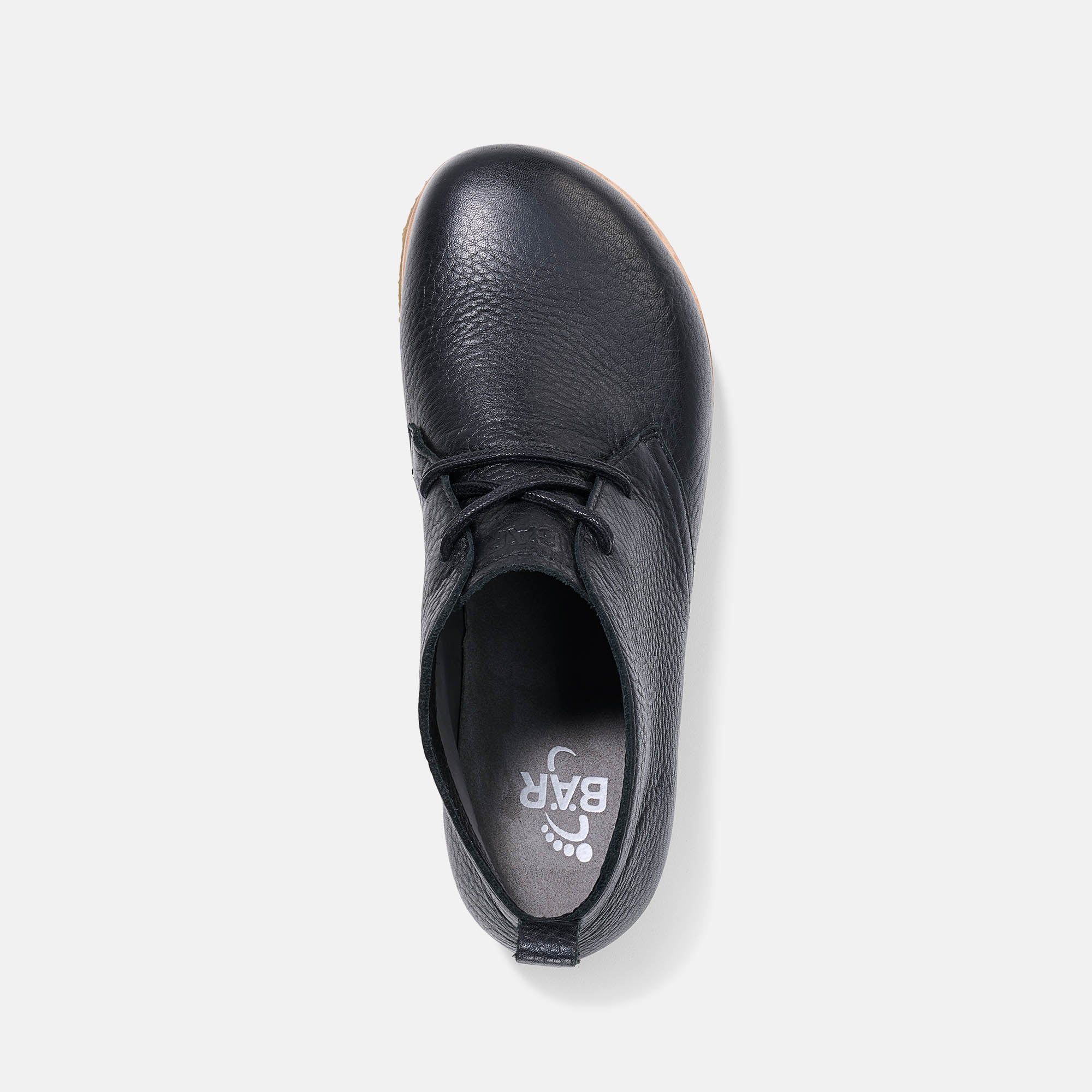 Schwarzer Stiefelette, Innensohle mit Logo. Helle Sohle. Lederstruktur sichtbar.