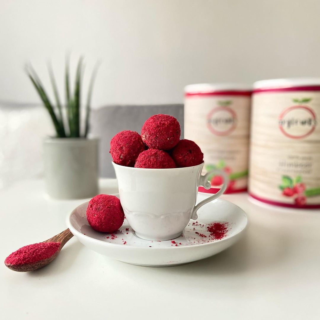 Himbeer-Kugeln in Tasse. Dose mit Himbeeren-Aufdruck. Logo myfruits, Schriftzug Himbeeren. Löffel mit Pulver.