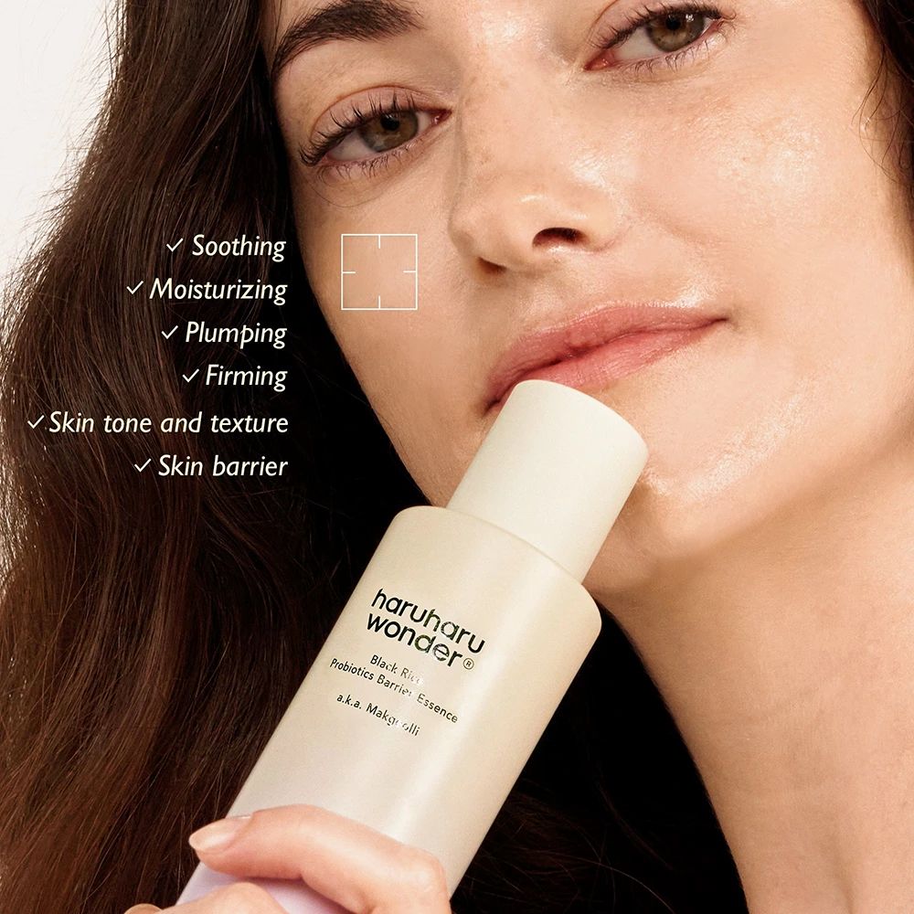 Frau hält Flasche. Aufschrift: haruharu wonder Black Rice Probiotics Barrier Essence. Text: Soothing, Moisturizing, Plumping, Firming.