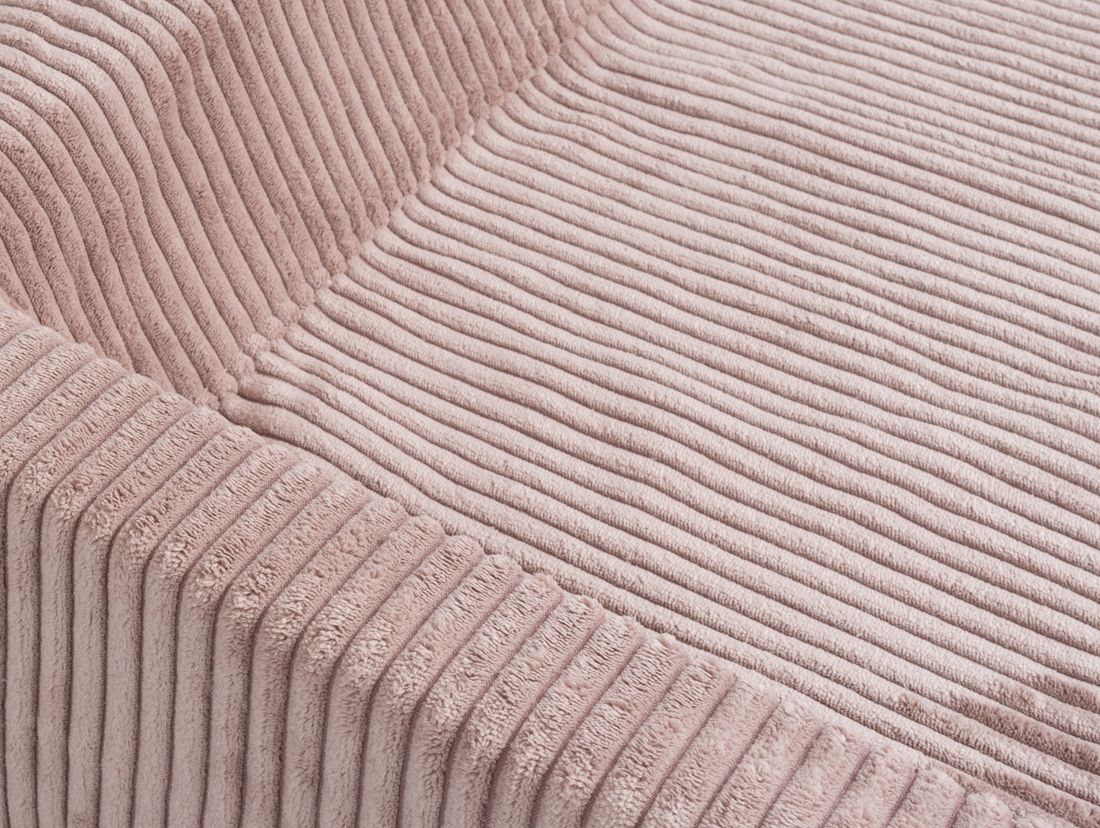 Nahaufnahme des rosa Cordstoffs eines orthopädischen Hundebetts. Struktur sichtbar.
