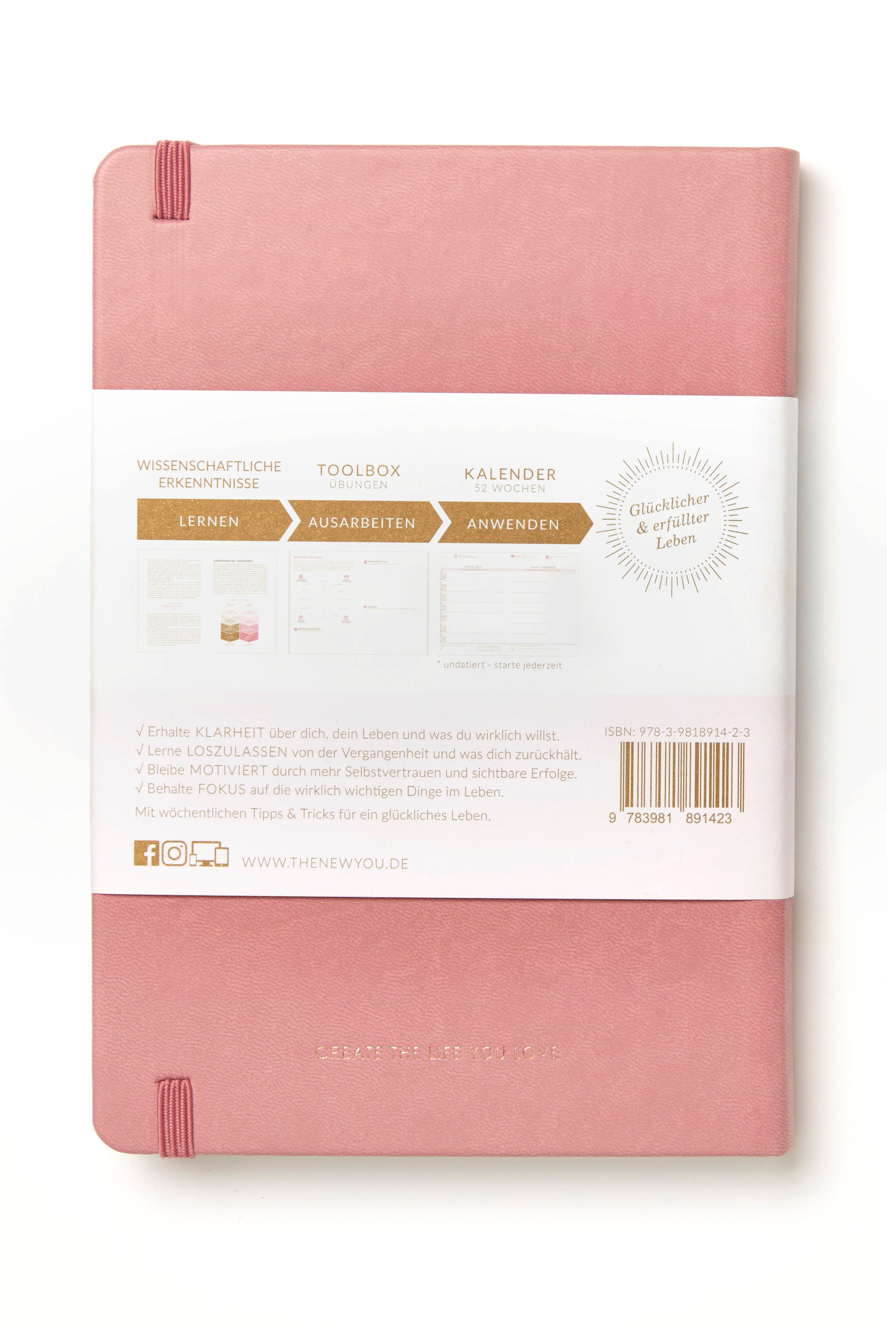 Rosa Buch mit Gummiband. Titel: THE NEW YOU. Aufkleber mit Text und Illustrationen. Barcode.