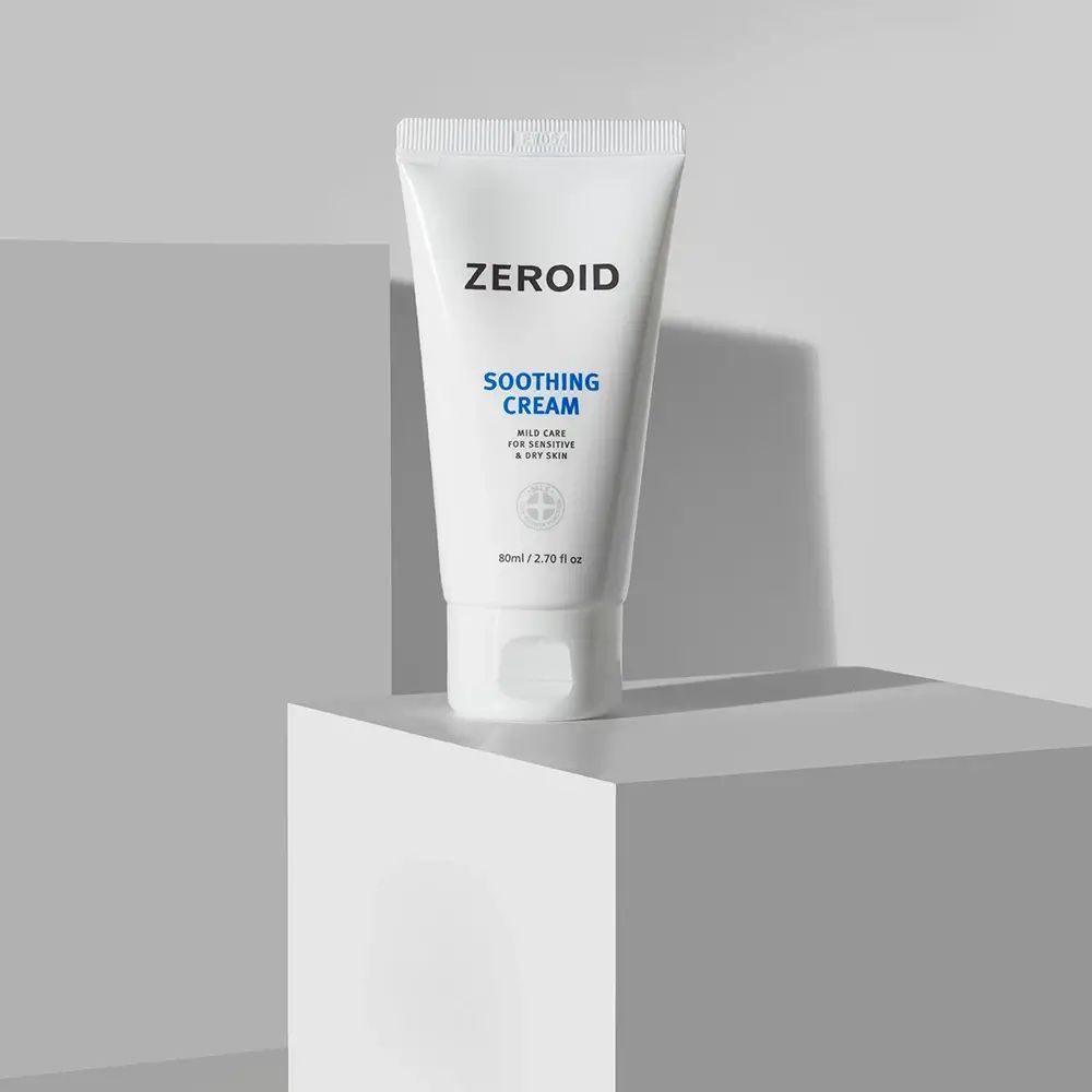 Weiße Tube ZEROID Soothing Cream auf weißem Podest. Blaue Schrift. Für empfindliche Haut.