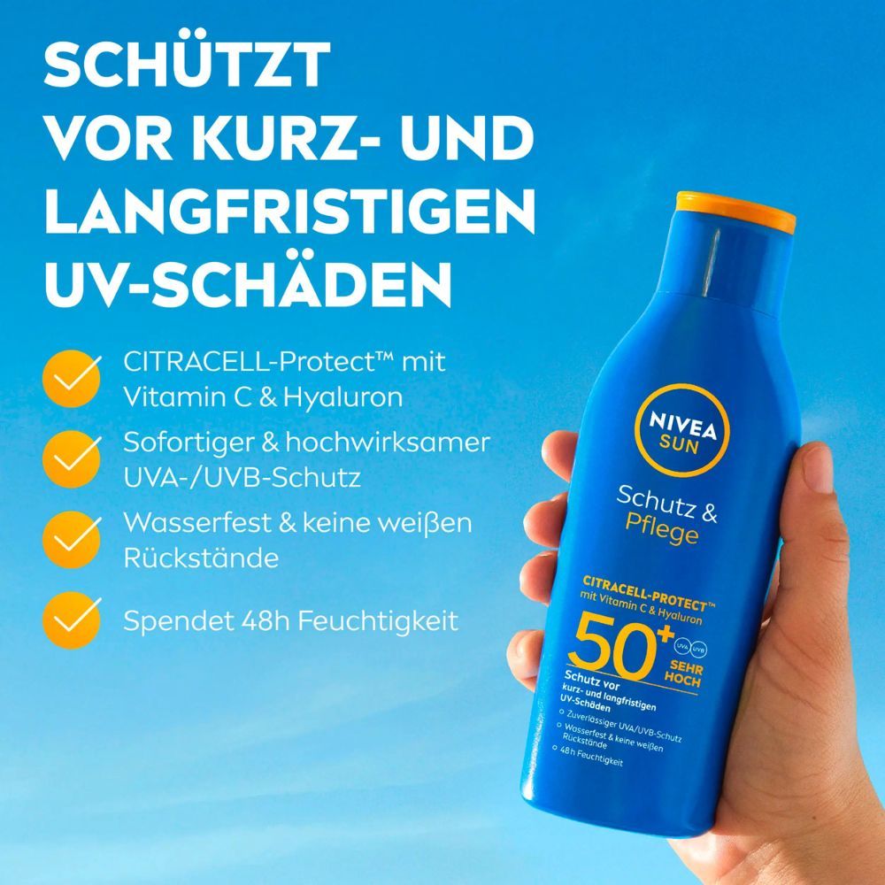 Hand hält blaue Sonnencreme-Flasche. Aufschrift: NIVEA SUN Schutz & Pflege, LSF 50. Gelber Deckel. Hintergrund: blauer Himmel und gelbe Markierungen.