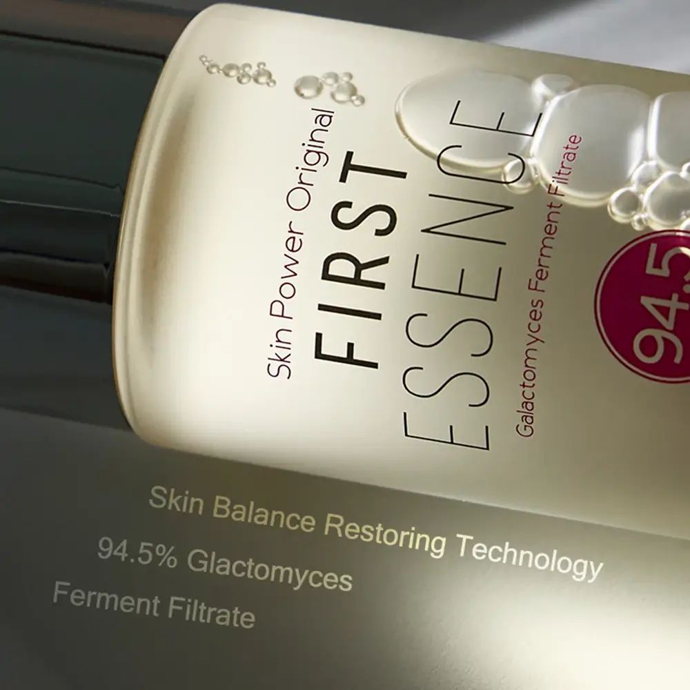 Nahaufnahme der Flaschenoberfläche. Aufschrift: FIRST ESSENCE, 94,5% Galactomyces Ferment Filtrat.
