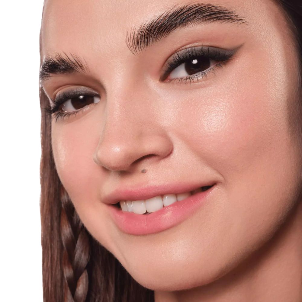 Nahaufnahme eines Gesichts. Augen mit Eyeliner. Dunkelbraune Augenbrauen. Offener Mund.