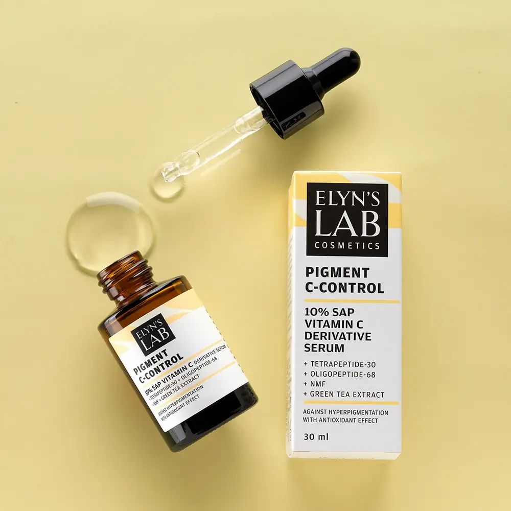 Produktflasche und Verpackung. Pipette daneben. Aufschrift: ELYN'S LAB Pigment C-Control Serum. Inhaltsstoffe auf dem Etikett.