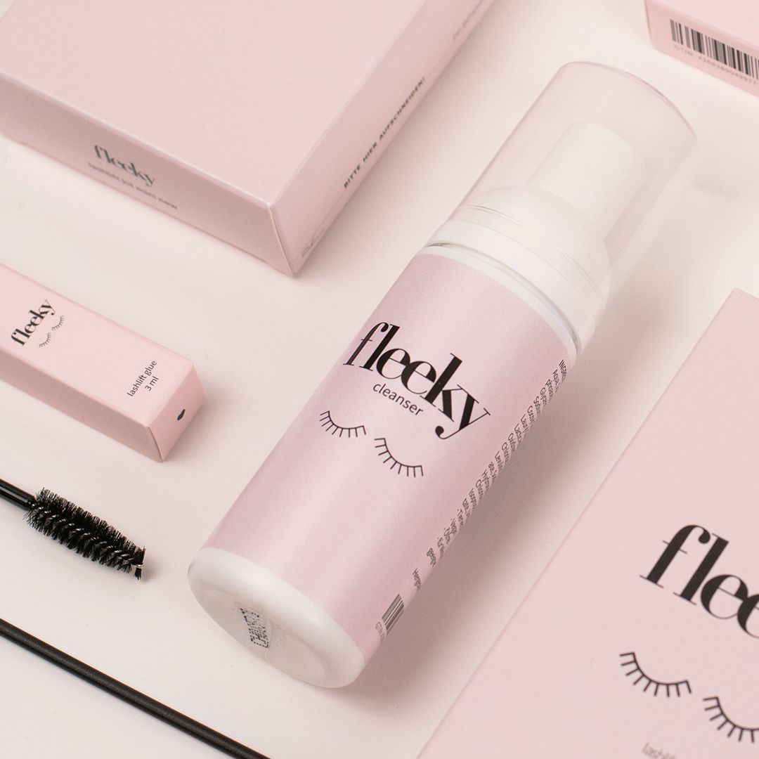 Fleeky Cleanser Flasche, rosa Verpackung, Wimpernbürste. Logo und Wimpern-Illustration auf Etiketten. Ölfreier Make-Up Entferner.