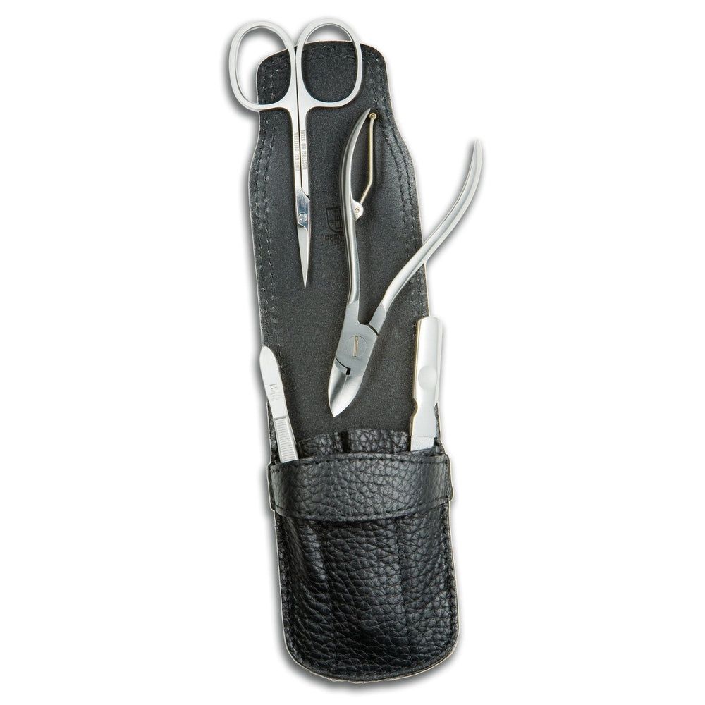 Vierteiliges Maniküre-Etui aus schwarzem Leder mit Nagelknipser, Schere, Pinzette und Hautschieber.