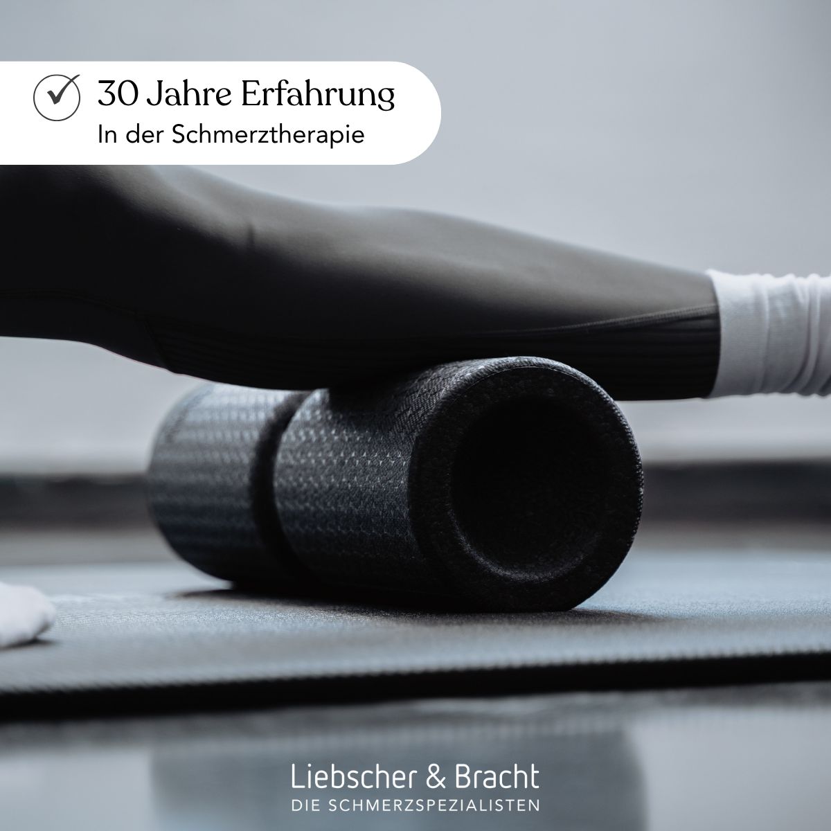 Nahaufnahme einer Faszienrolle unter dem Bein einer Person. "30 Jahre Erfahrung in Schmerztherapie".