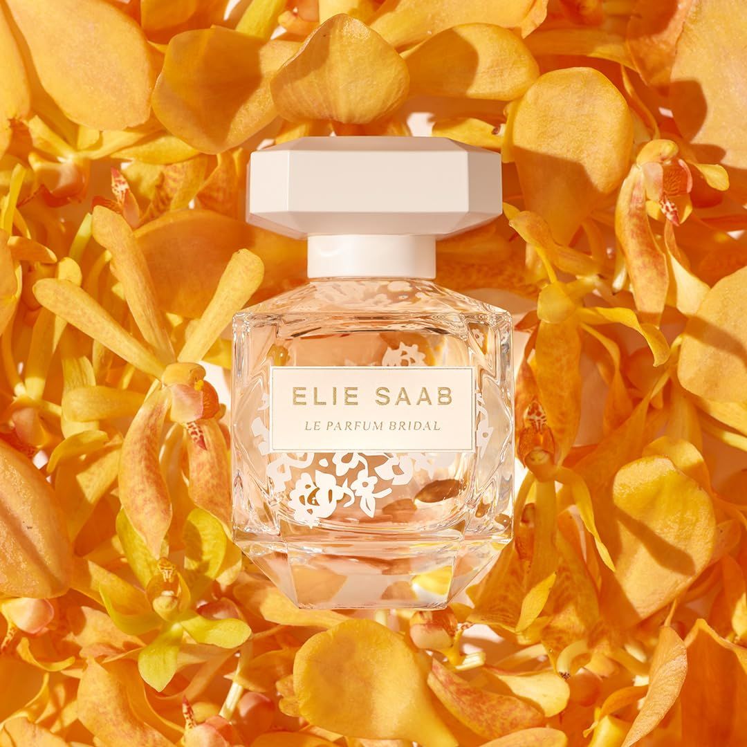 ELIE SAAB Le Parfum Bridal Flakon, umgeben von gelben Blütenblättern. Beige Deckel.