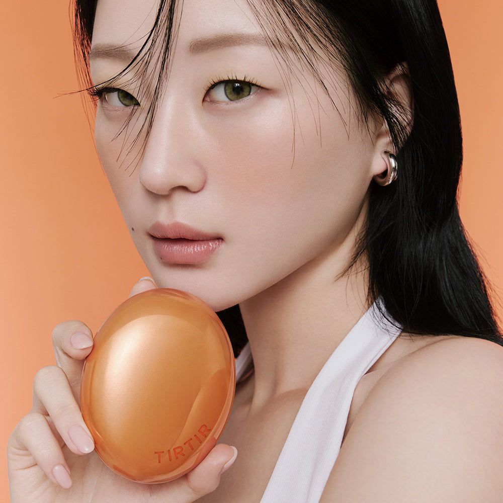 Frau hält TIRTIR Mask Fit Ai Filter Cushion Foundation in oranger Dose.
