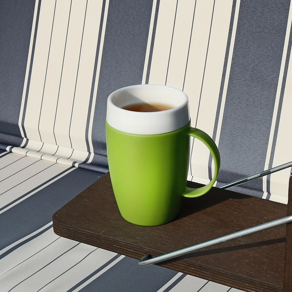 Grüner Becher mit weißem Rand und Henkel. Der Becher steht auf einem Holzbrett.