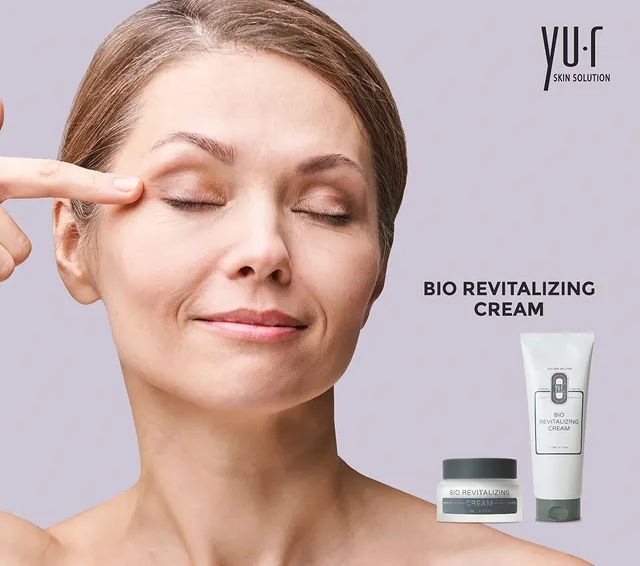 Frau berührt Augenpartie. Aufschrift: Bio Revitalizing Cream. Marke: Yu.r.