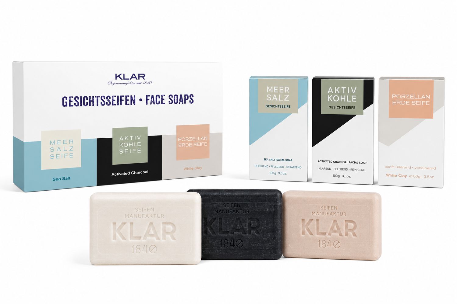 Geschenkset mit drei Seifen und Verpackungen. Meer Salz, Aktivkohle und Porzellanerde. Seifen mit Klar-Logo.