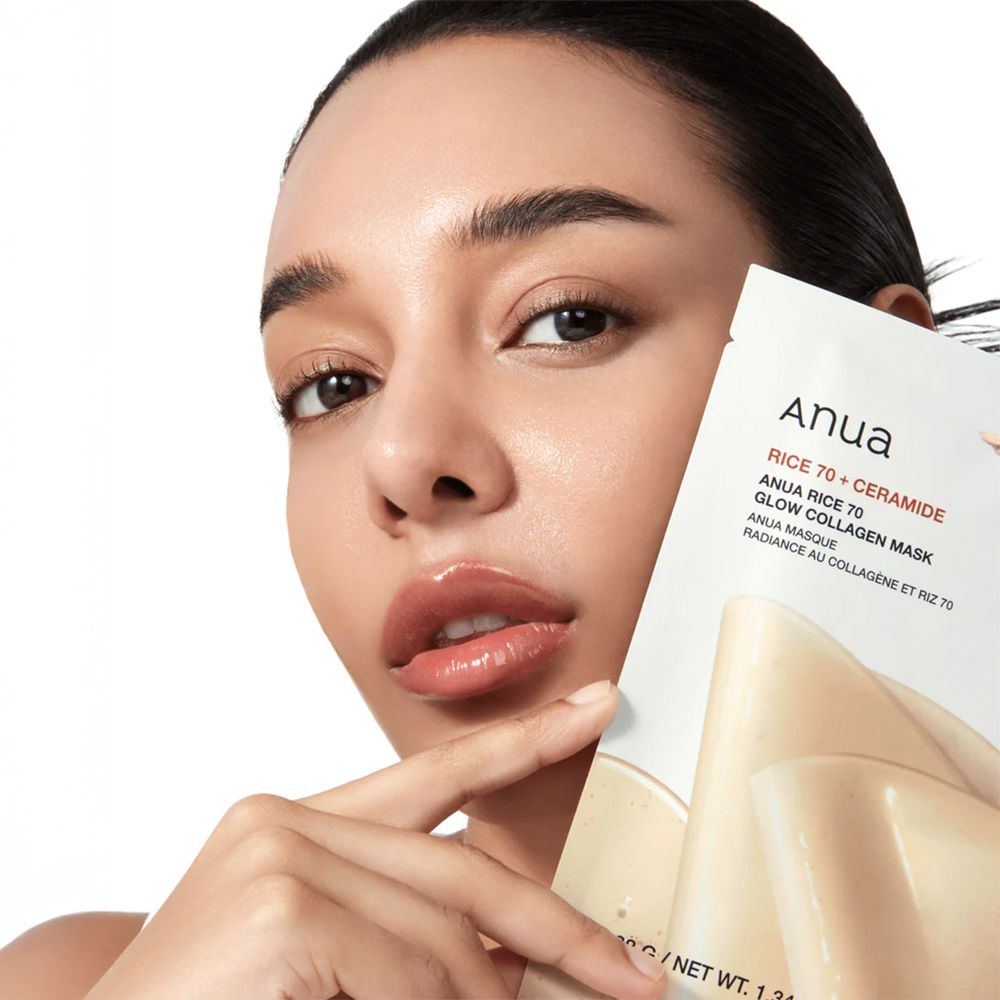 Frau hält die Anua Rice 70 Glow Collagen Maske. Gesicht mit Maske. Text: Anua Rice 70 + Ceramide.