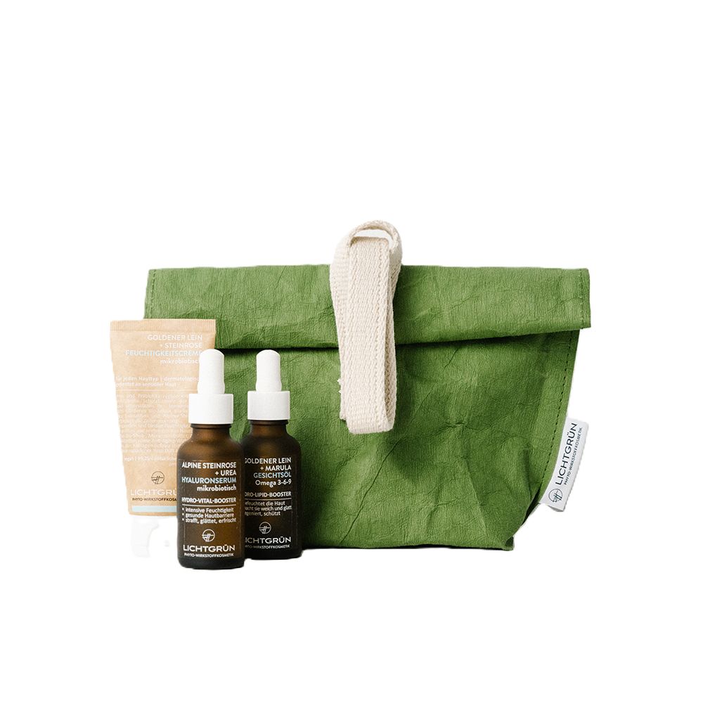 Grüne Tasche mit Griff, zwei braunen Flaschen, einer Tube und einem Etikett mit LICHTGRÜN®. Produkte für die Hautpflege.