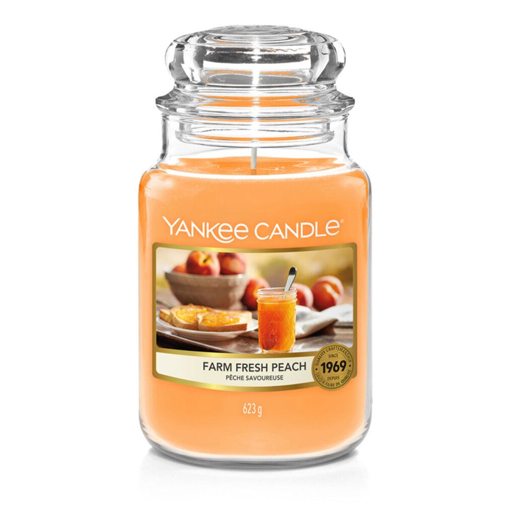 Duftkerze mit Deckel. Aufkleber mit Pfirsich-Motiv und Schriftzug. Aufschrift: Yankee Candle, Farm Fresh Peach, 623g.