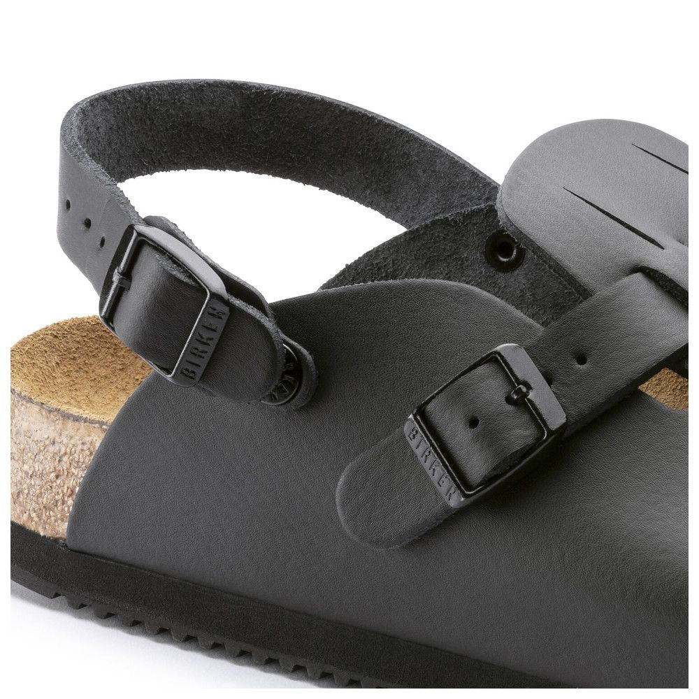 Nahaufnahme eines schwarzen Birkenstock Kay SL Clogs. Detail des Riemens mit Schnalle und Logo.