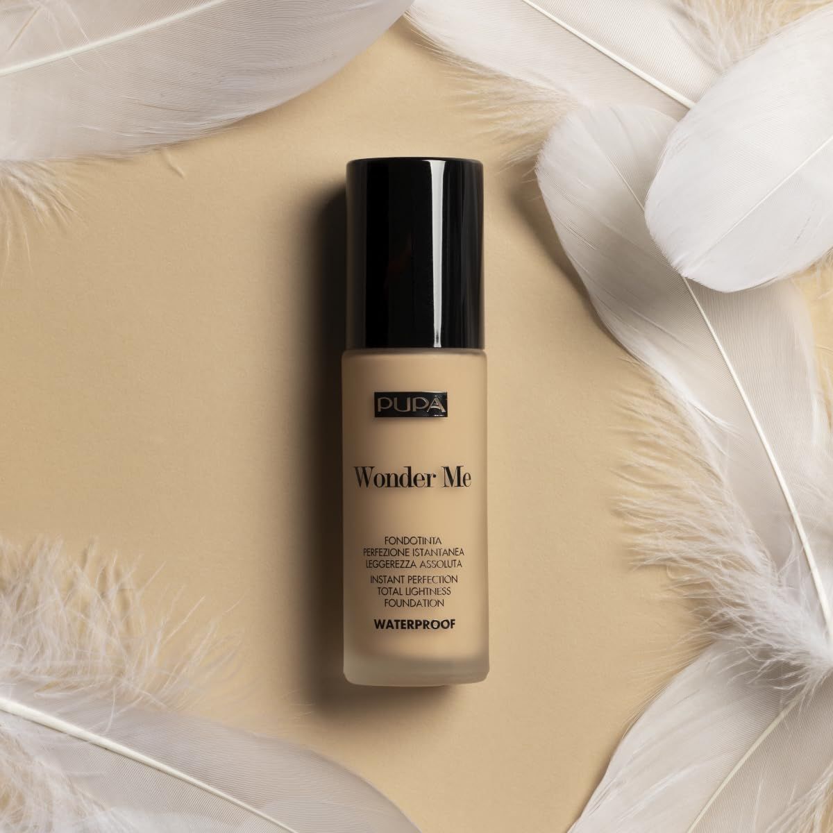 Pupa Wonder Me Foundation Flasche mit Federn im Hintergrund.