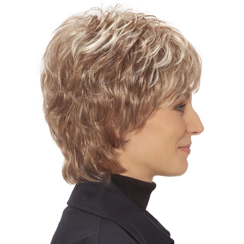 Kurzhaarperücke mit blonden Strähnen. Die Frau trägt einen schwarzen Rollkragenpullover. Dreiviertelansicht.