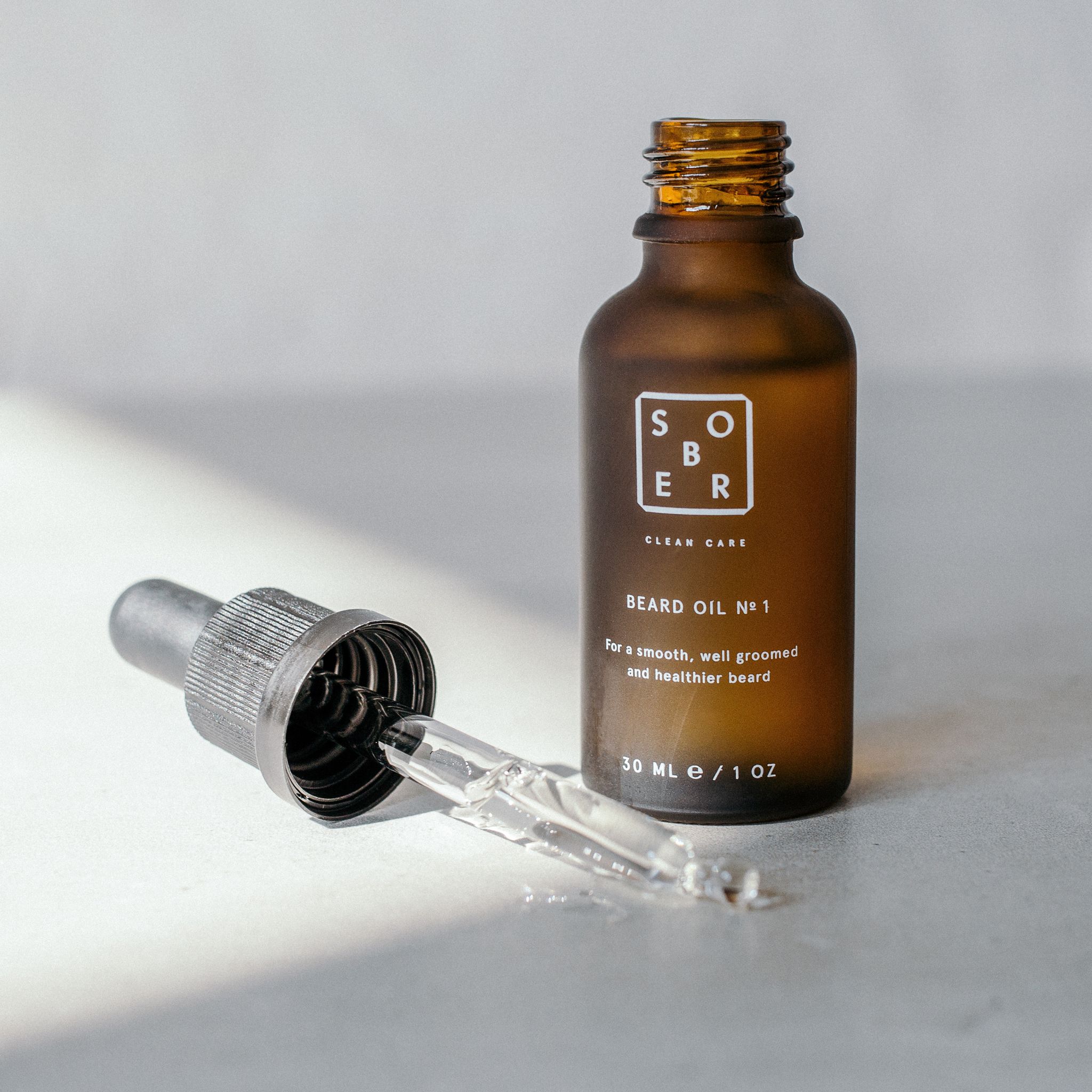Braune Glasflasche mit Pipette. Aufschrift: SOBER, BEARD OIL NO. 1, 30 ml/1 OZ. Pipette daneben.