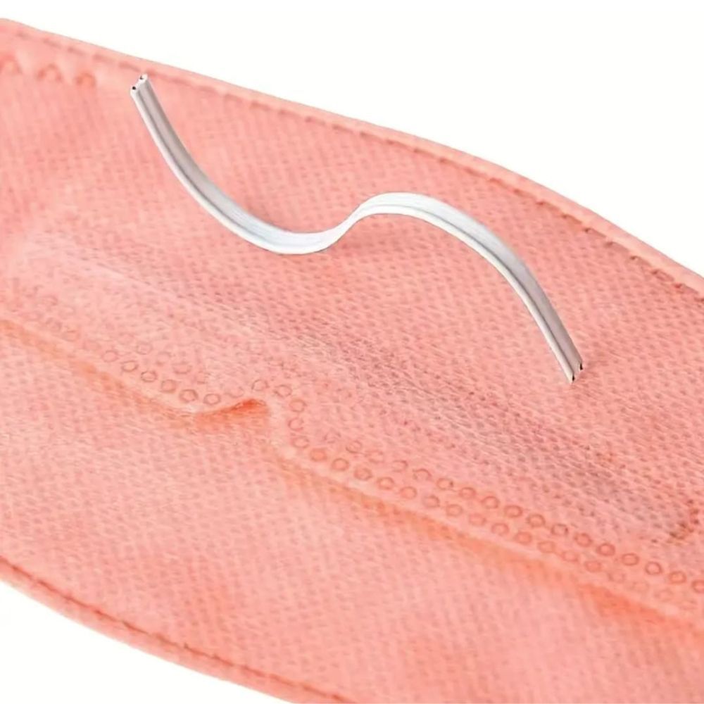 Metallnasenbügel für Gesichtsmasken. Gebogen, silberfarben. Liegt auf einem rosafarbenen Maskenmaterial.