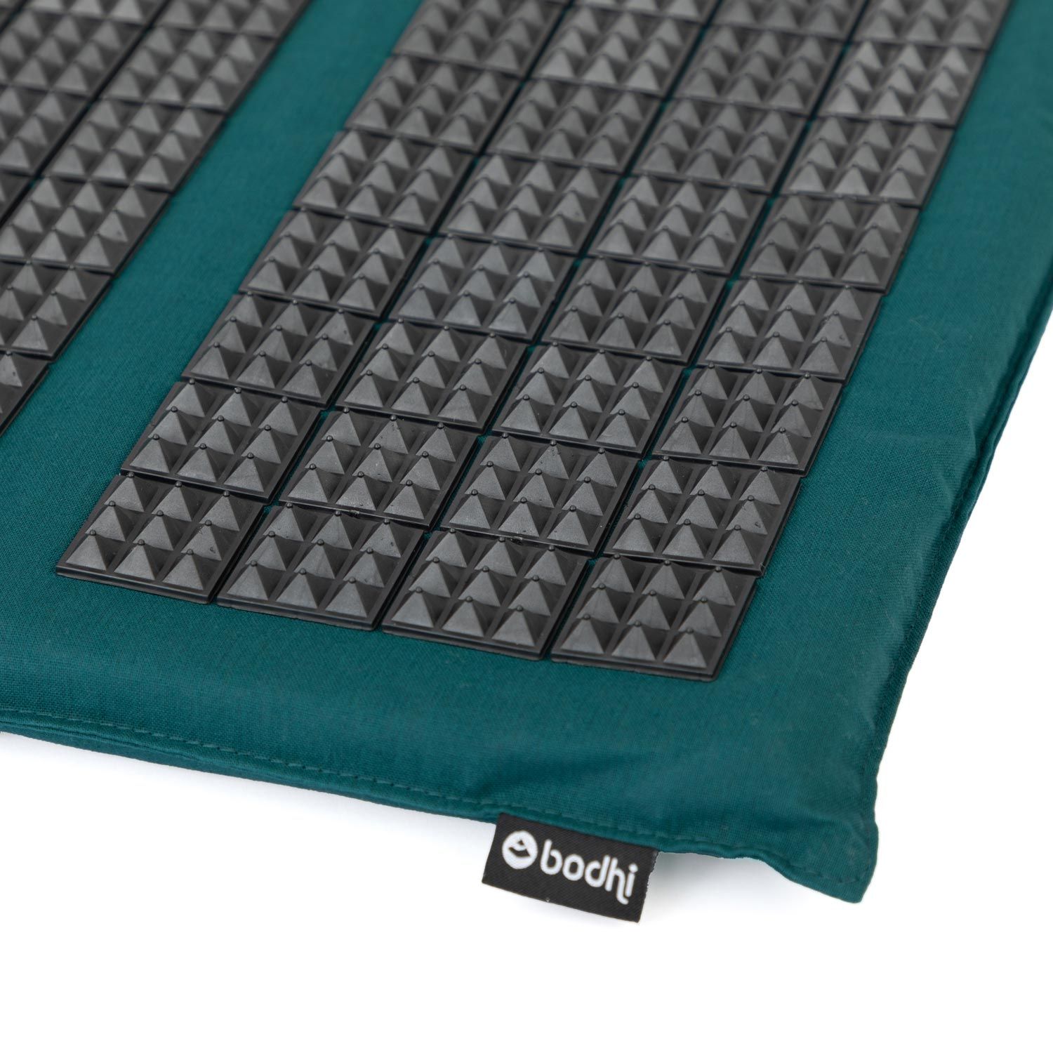 Detailansicht der Akupressur-Fußmatte. Schwarze Noppen auf grünem Stoff. Bodhi-Logo.