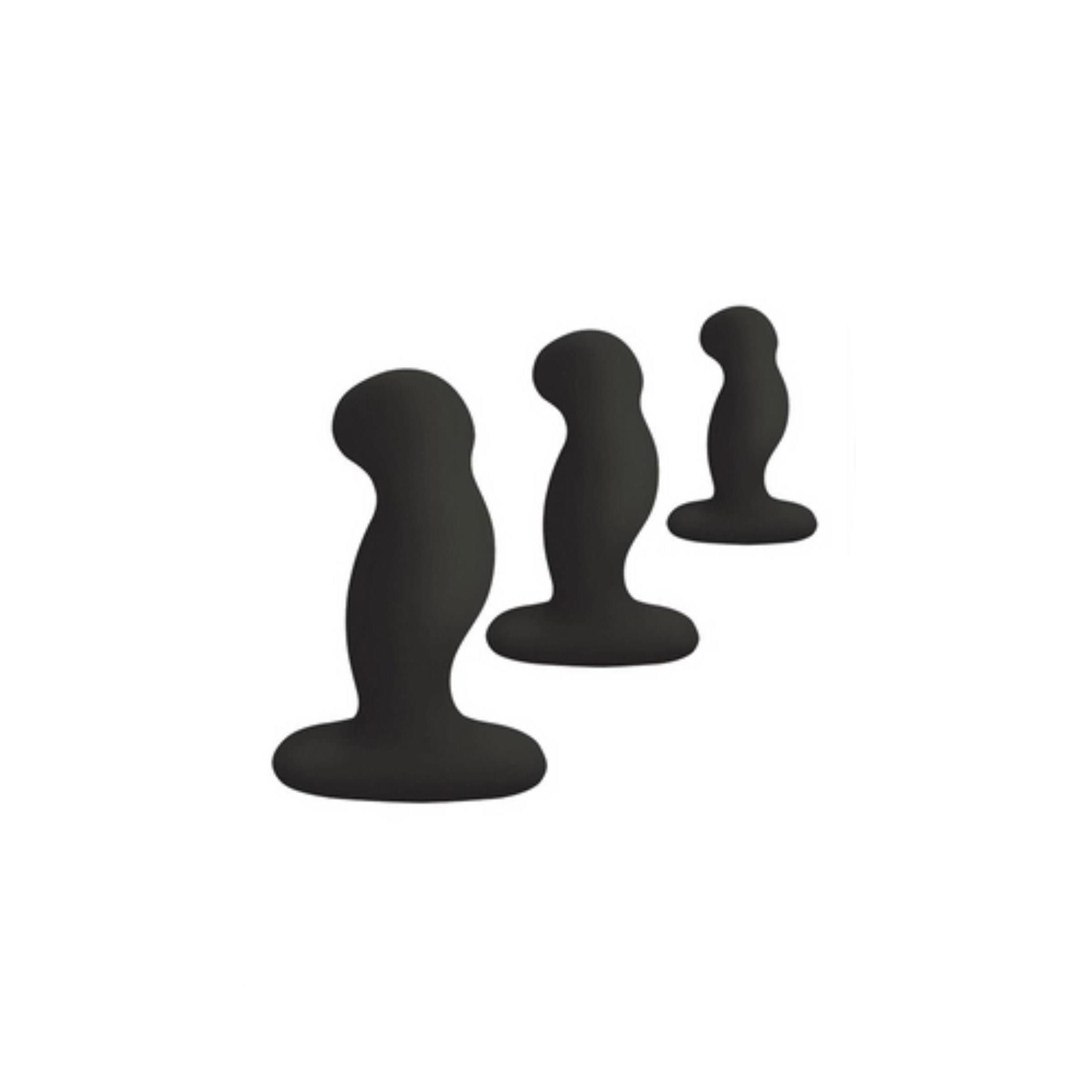 Drei schwarze, unterschiedlich große, anale Plugs aus Silikon. Sie stehen nebeneinander auf weißem Hintergrund.