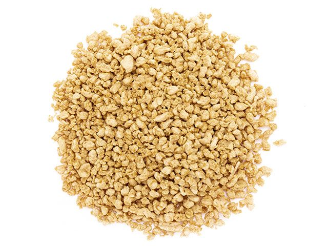 Haufen von texturierten Sojaproteinen, kleine, helle braune Granulate.