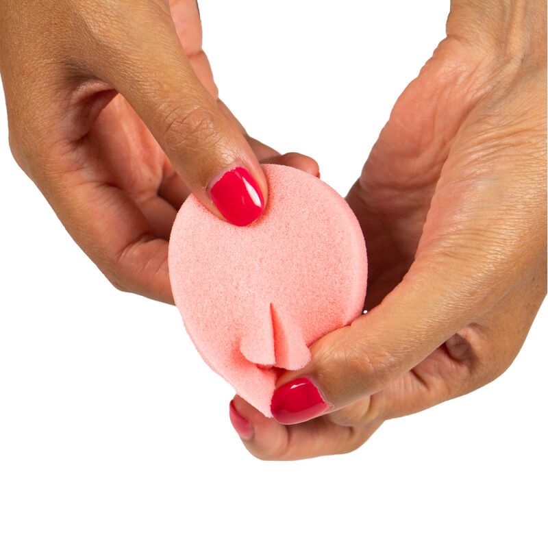 Hände halten einen rosa Schwamm. Der Schwamm ist gefaltet, um eine Form zu bilden.