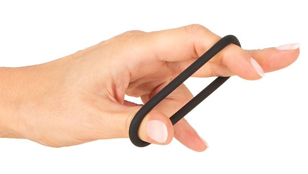 Hand hält schwarzen Magic Shiver Ring zwischen Fingern.