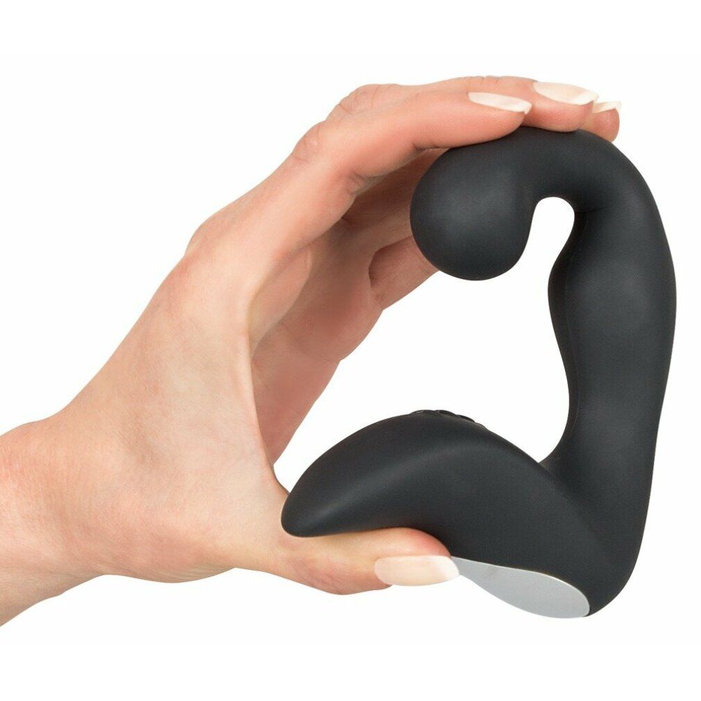 Schwarzes Wellness-Produkt, in Hand gehalten. Abgerundeter Kopf, gebogene Form. Weißer Akzent an der Basis.