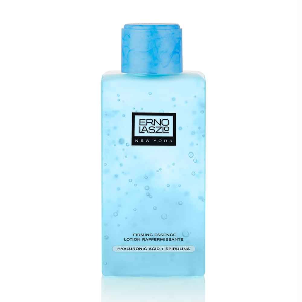 Erno Laszlo Lift Essence Lotion. Rechteckige Flasche mit blauem Inhalt. Schwarzes Etikett mit Logo und Text.