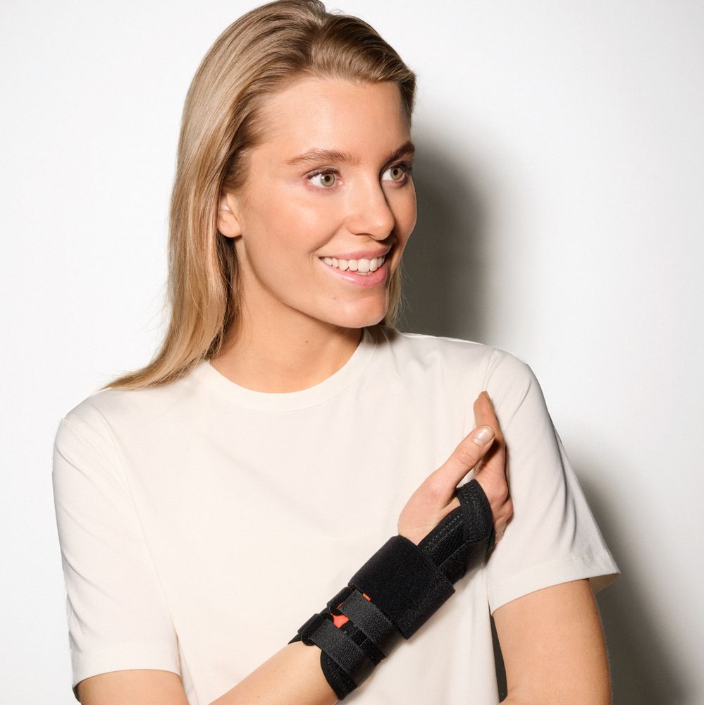 Frau trägt eine schwarze Handgelenkbandage am linken Arm.