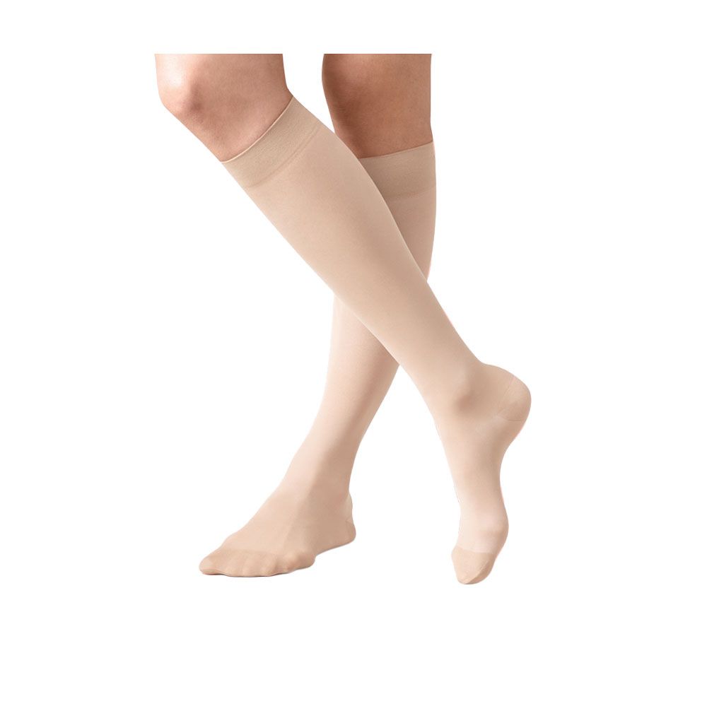Beige Kniestrümpfe, 70 den, auf Beinen. Feine, transparente Textur. Nahtloser Abschluss am Oberschenkel.