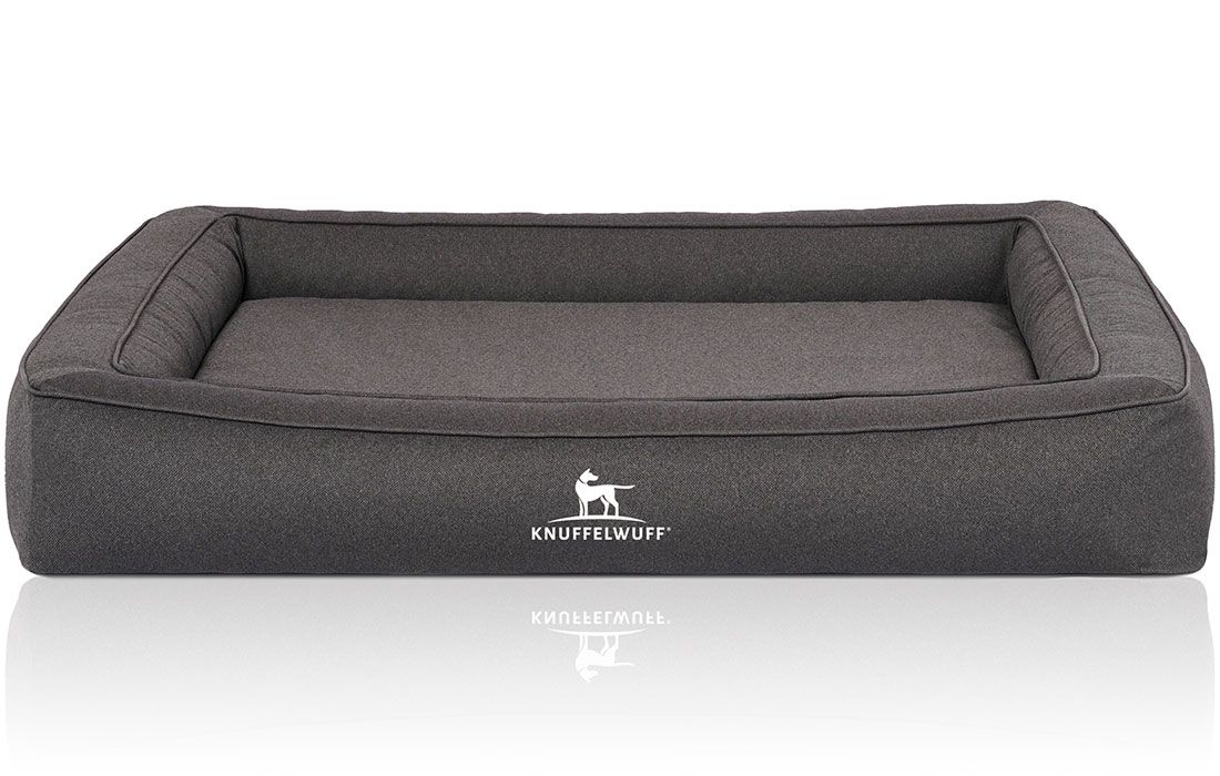 Graues orthopädisches Hundebett mit erhöhtem Rand. Das Logo "Knuffelwuff" ist auf der Vorderseite sichtbar.