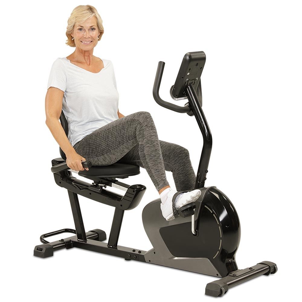 Frau sitzt auf einem Ergometer. Sie trägt Sportkleidung. Das Gerät hat ein Display.