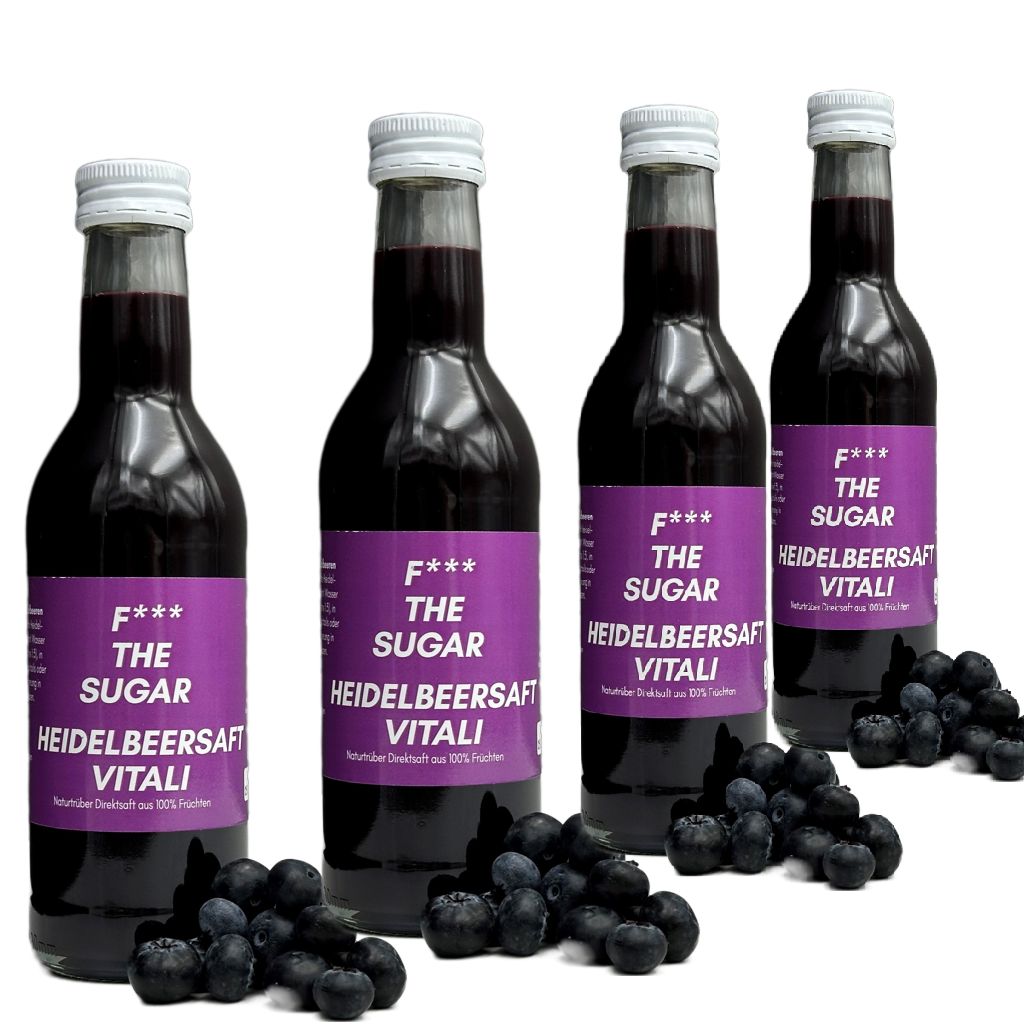 Vier Flaschen Heidelbeersaft mit lila Etiketten. Aufschrift: F*** THE SUGAR, Vitali Heidelbeersaft. Blaubeeren liegen daneben.