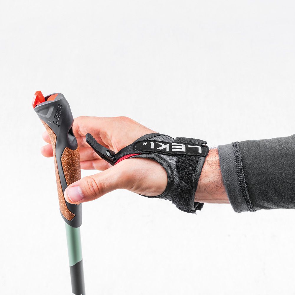 Hand mit Nordic-Walking-Stock. Der Stock ist am Handgelenk befestigt. Korkgriff, schwarze Handschlaufe mit LEKI-Logo.