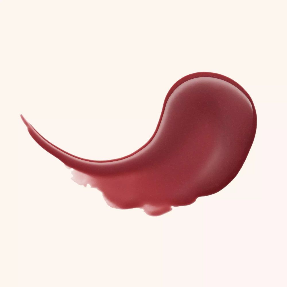 Ausgestrichene Lippenbalsam-Farbe. Farbton: dunkles Rosa. Auf hellem Hintergrund.