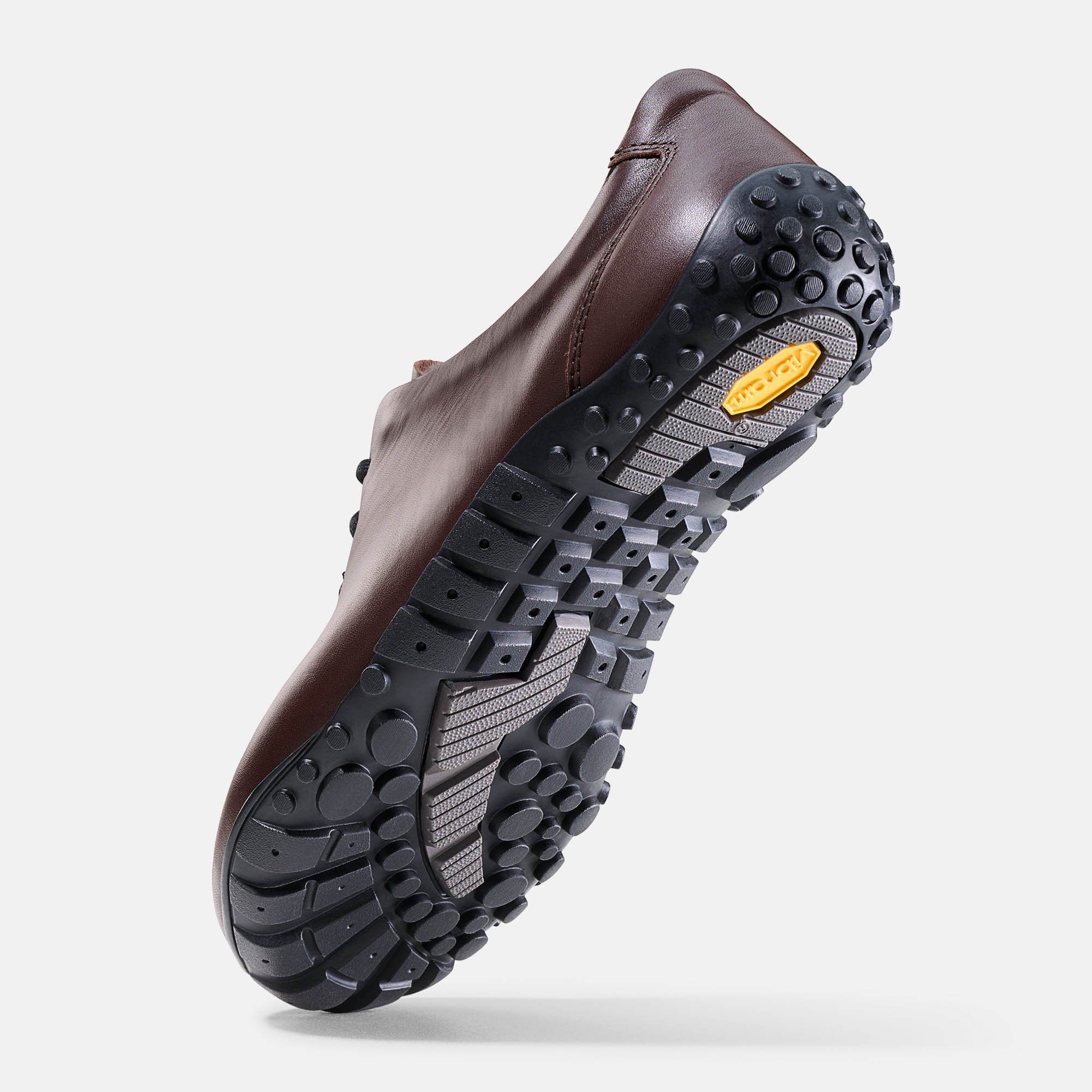 Braune Lederschnürschuh, Unterseite. Schwarze Sohle mit Profil. Gelbes Vibram-Logo.