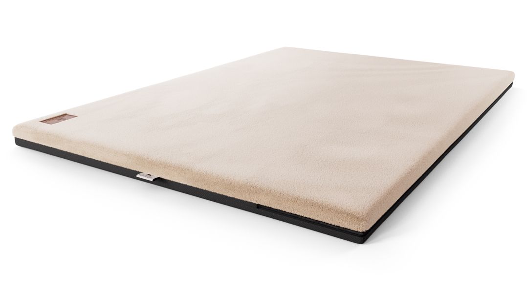 Orthopädische Hundematte, beige, mit schwarzem Rand. Label an der Seite.