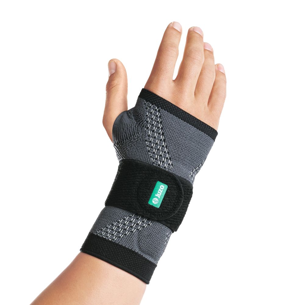 Handgelenkbandage anthrazit am Handgelenk. Schwarzer Klettverschluss mit grünem Logo. Graues, strukturiertes Material.