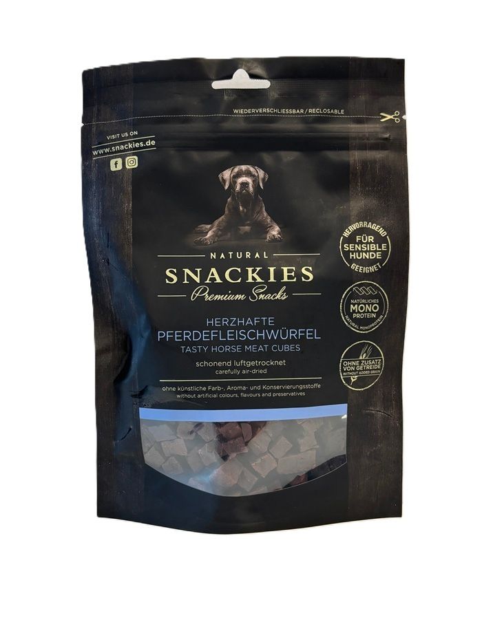Schwarze Verpackung mit Snackies-Logo und Produktbezeichnung: Herzhafte Pferdefleischwürfel. Sichtfenster zeigt Würfel.
