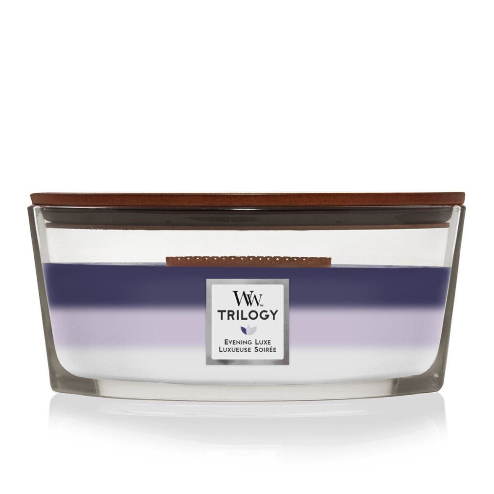 Kerze mit drei Farbzonen. Holzdeckel. Aufkleber mit Logo und Text: Trilogy, Evening Luxe, Luxueuse Soirée.