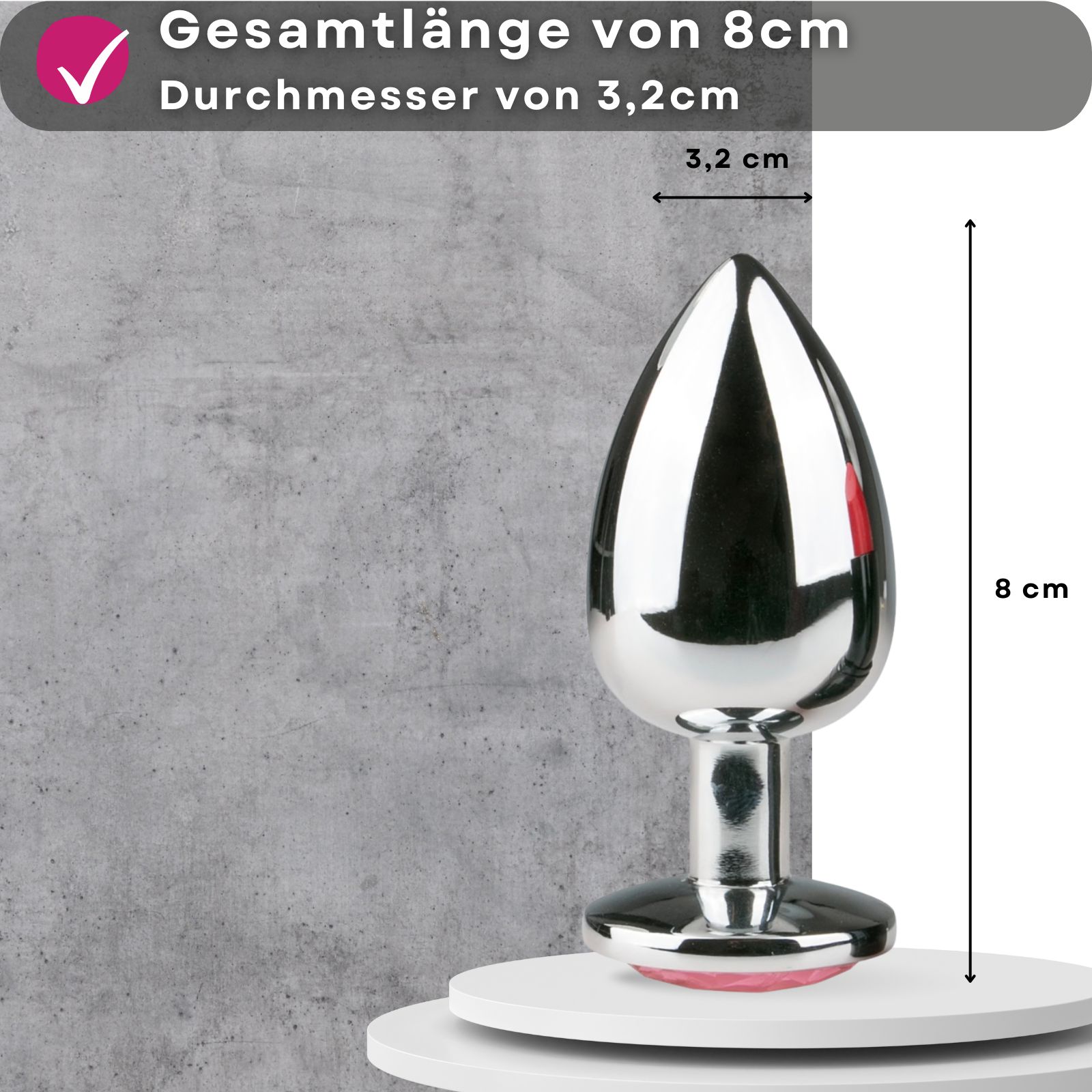 Analplug aus Metall. Länge 8 cm, Durchmesser 3,2 cm. Paar im Hintergrund.