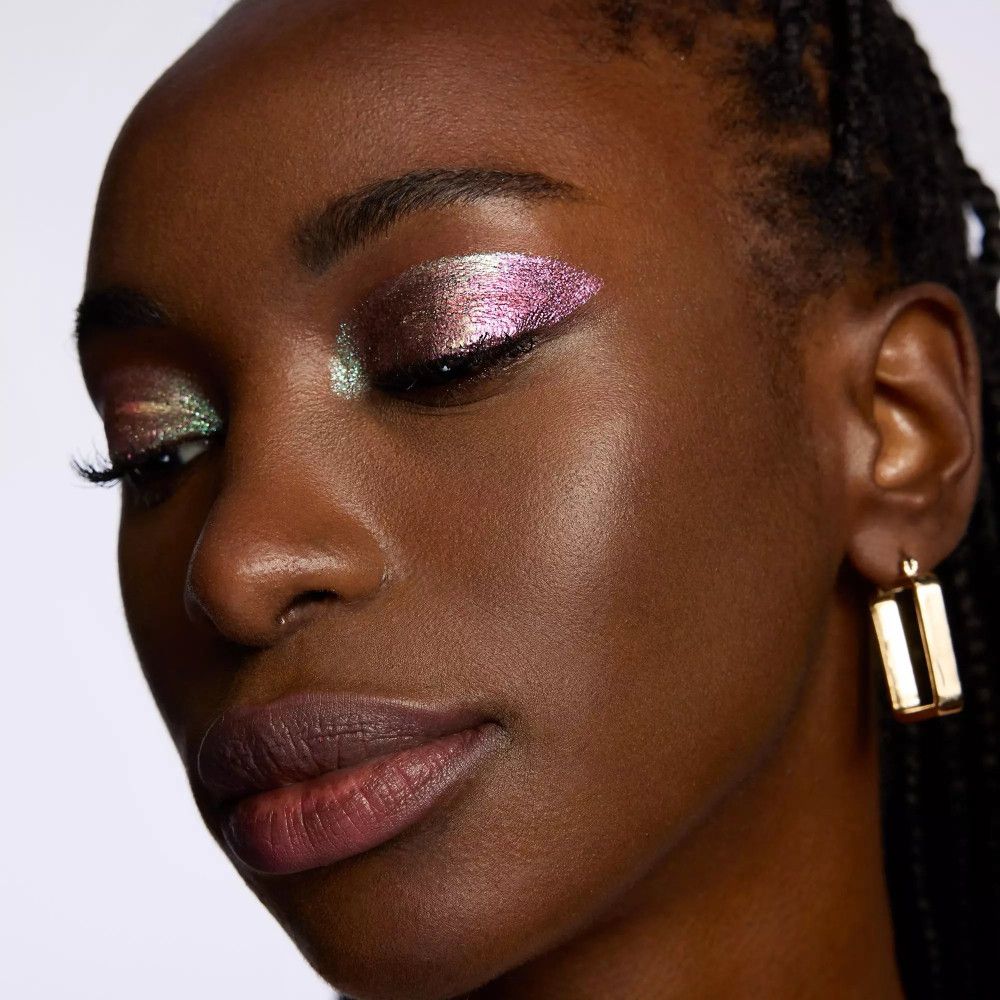 Nahaufnahme einer Frau mit geschminkten Augen. Mehrfarbiger Lidschatten. Dunkle Haut.