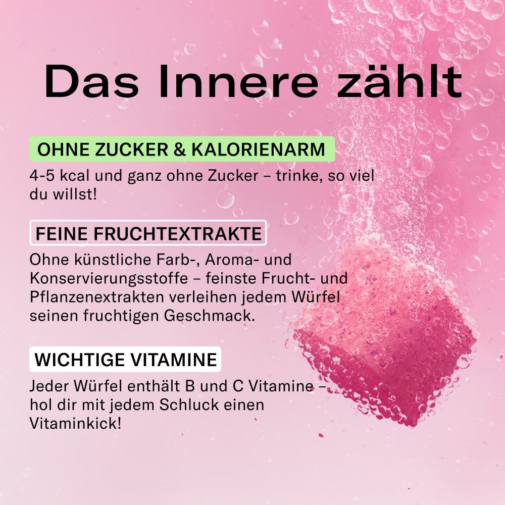 Ein pinker waterdrop® Microdrink Würfel löst sich in sprudelndem Wasser auf.